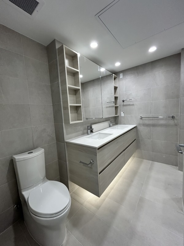 Finished bathroom with floating double vanity and tiled walls