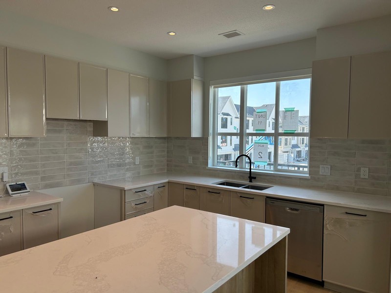 Kitchen with quartz island and tiled backsplash