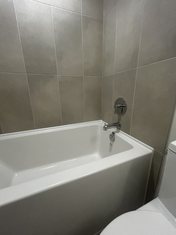 Bathtub sealed with fresh silicone in a Merchant suite