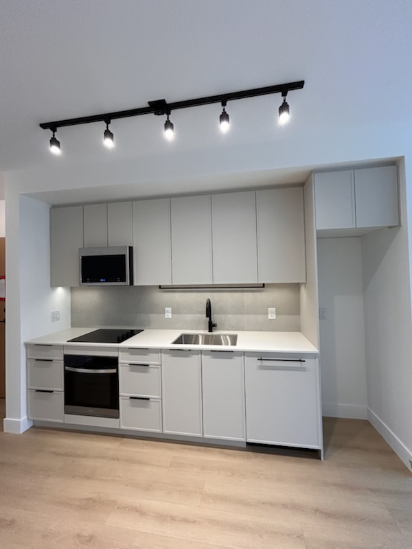 White kitchen with integrated appliances in a Moody Yards home