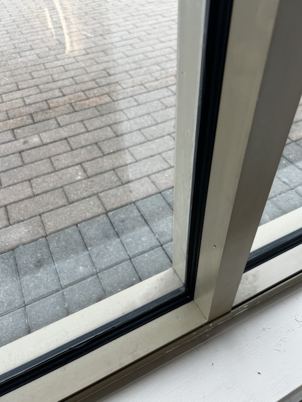 Finished black silicone line at a storefront window corner